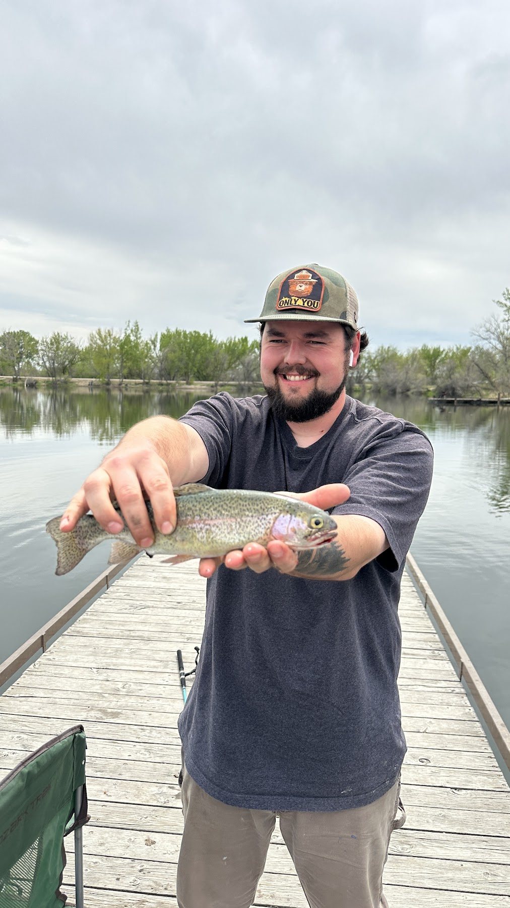 A family member holding a fish by the water