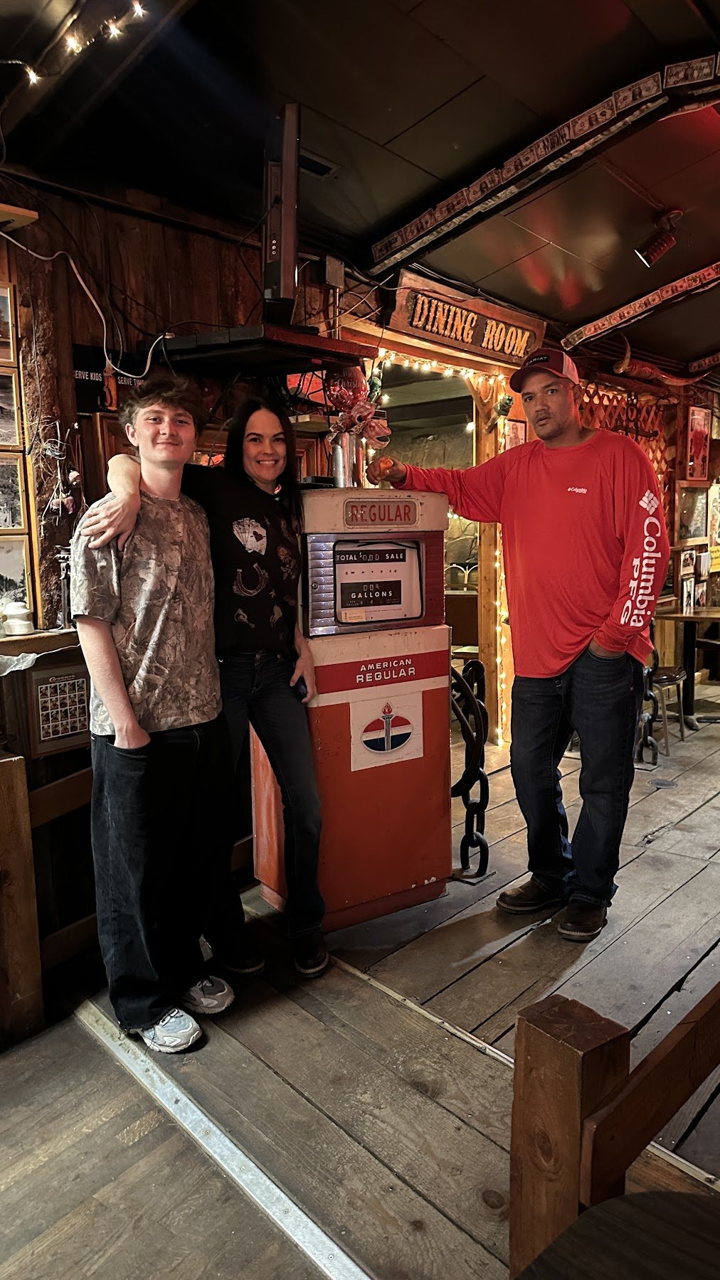 Family members standing beside a vintage pump